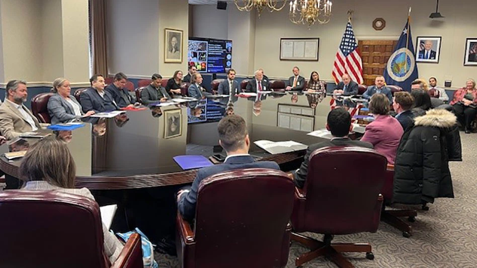 People gathered around a table in government building.
