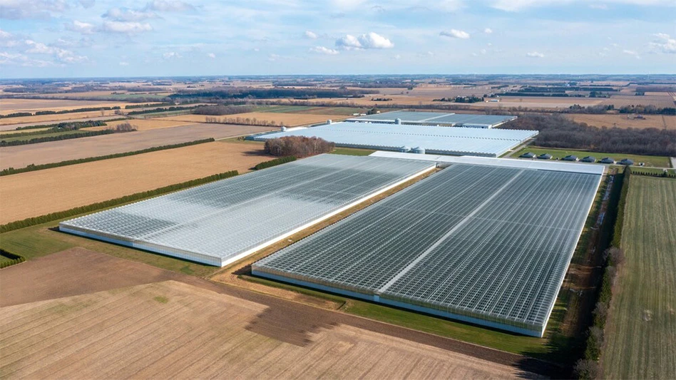 An aerial view of a large commercial greenhouse surrounded by fields.