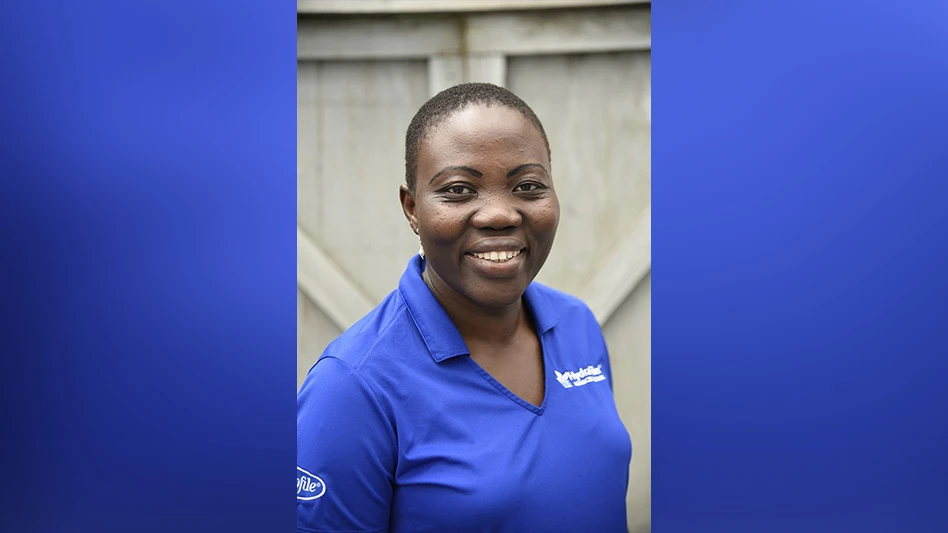 A smiling woman with short black hair wearing a royal blue polo shirt.