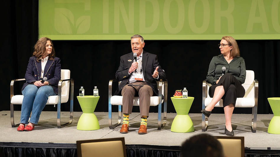 Three people sitting on a stage at Indoor Ag-Con.
