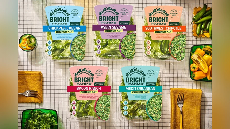 Plastic packages of salad meal kits on a table.